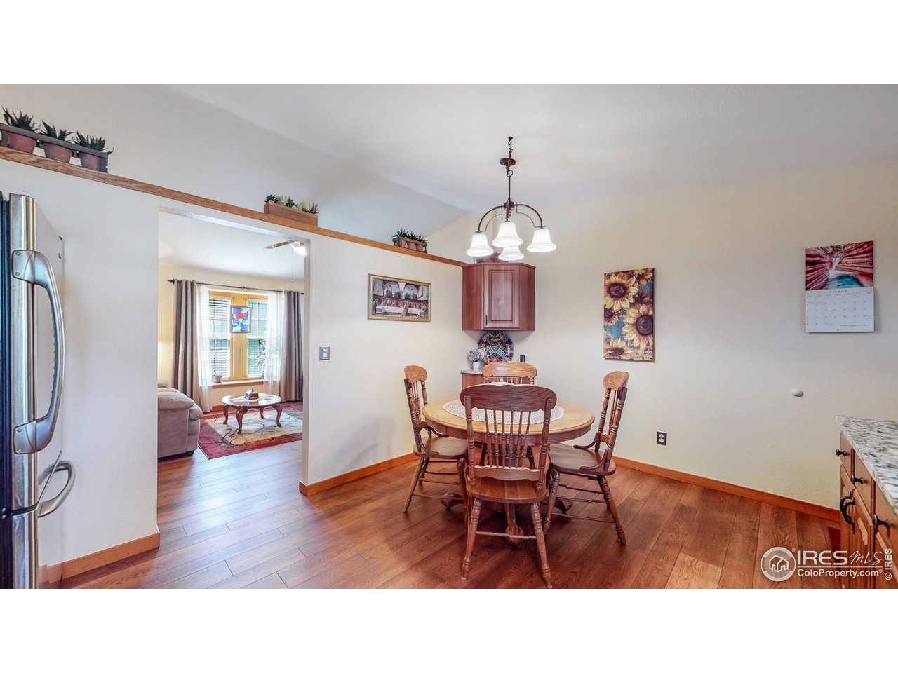 1554 Ervine Avenue Longmont, CO 80501 - Photo 8 of 31 a view of dining room and livingroom with furniture wooden floor a chandelier