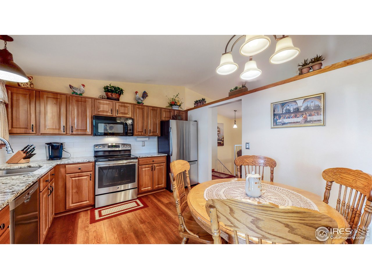 1554 Ervine Avenue Longmont, CO 80501 - Photo 10 of 31 a kitchen with stainless steel appliances kitchen island granite countertop a sink and cabinets