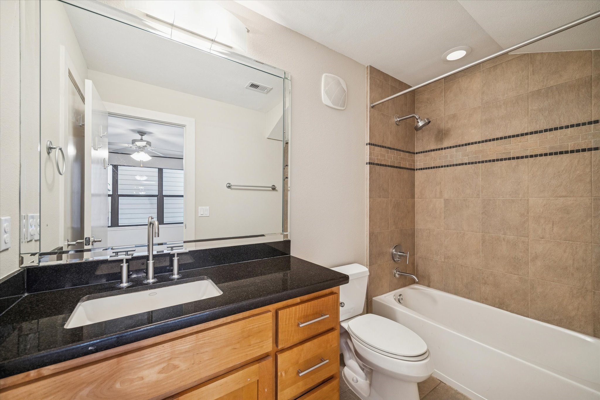 220 Detering Street Houston, TX 77007 - Photo 21 of 27 a bathroom with a granite countertop sink a toilet a mirror and shower