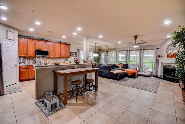 a kitchen with stainless steel appliances kitchen island granite countertop a table and chairs