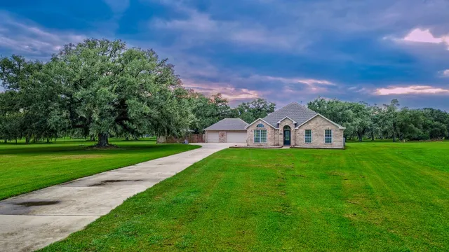 a front view of a house with a yard and trees