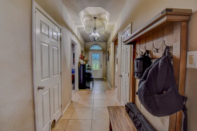 a view of a hallway with closet and a chandelier