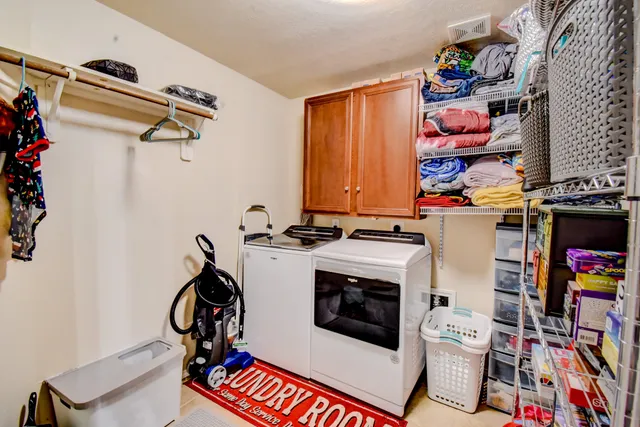 a utility room with dryer washer and a view of living room