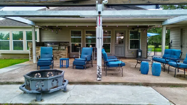 a view of a patio with table and chairs potted plants and floor to ceiling window