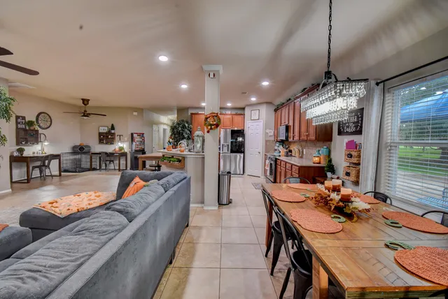 a view of a dining room and livingroom with furniture a rug a kitchen and a chandelier