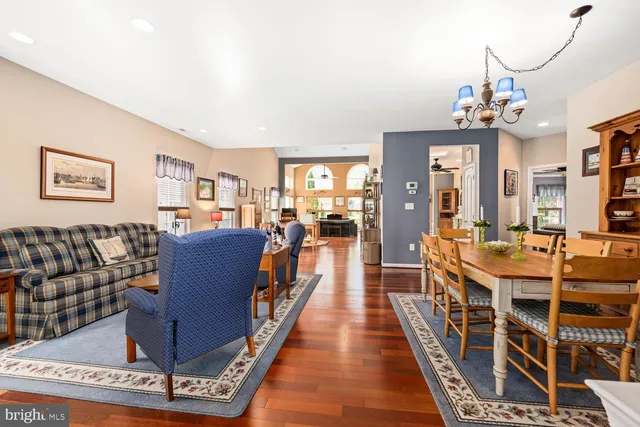 a living room with furniture a chandelier and a dining table