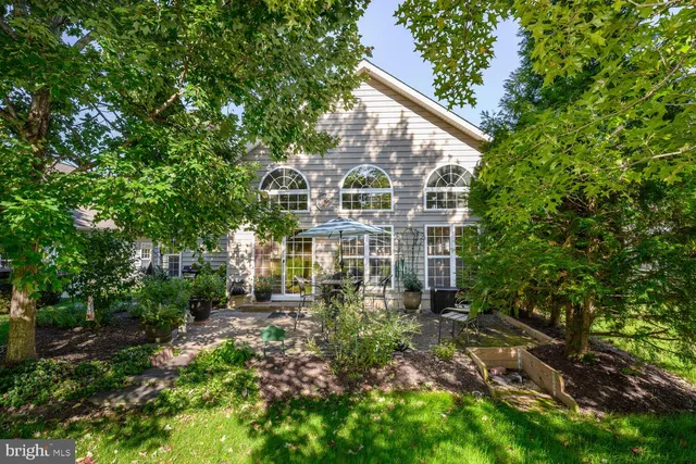 a view of a big yard in front of a house with plants and trees
