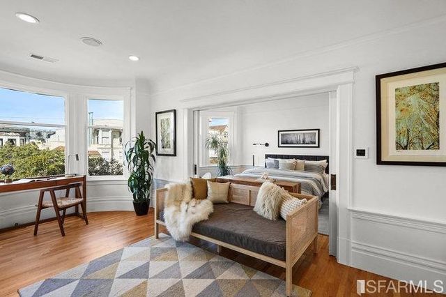 a view of a room that has a bed and a table in it