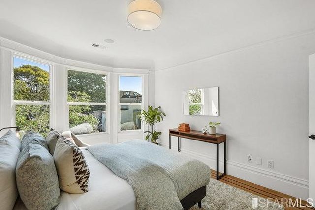 a bedroom with a bed and a large window