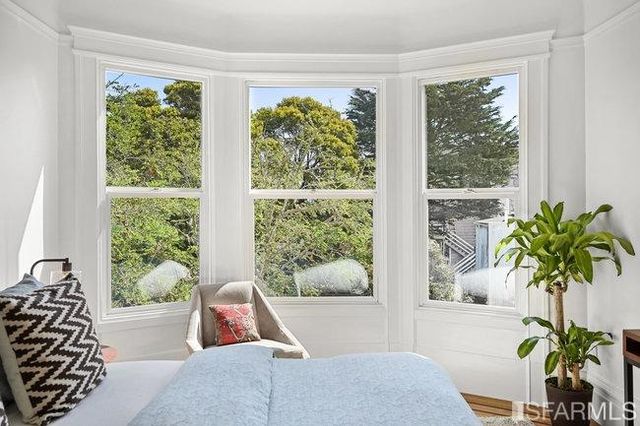 a bedroom with two beds and a large window