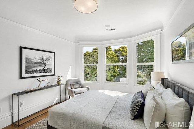 a bedroom with a bed and a large window