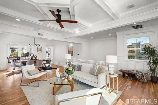 a living room with furniture a fireplace and a open kitchen view
