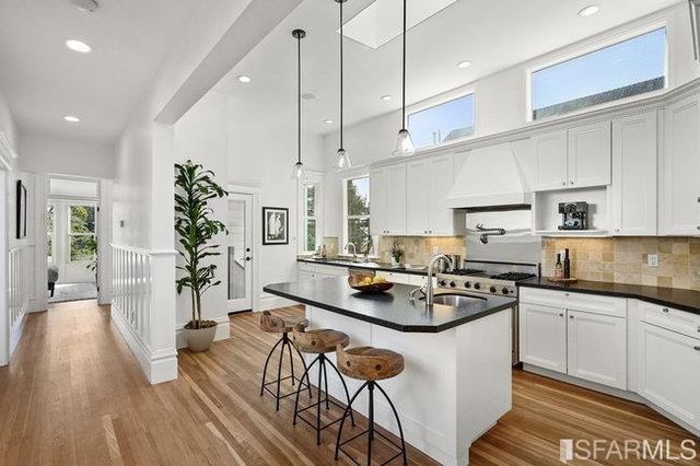 a kitchen with stainless steel appliances a sink stove and cabinets