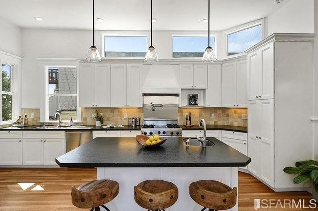 a kitchen with a stove a sink and cabinets