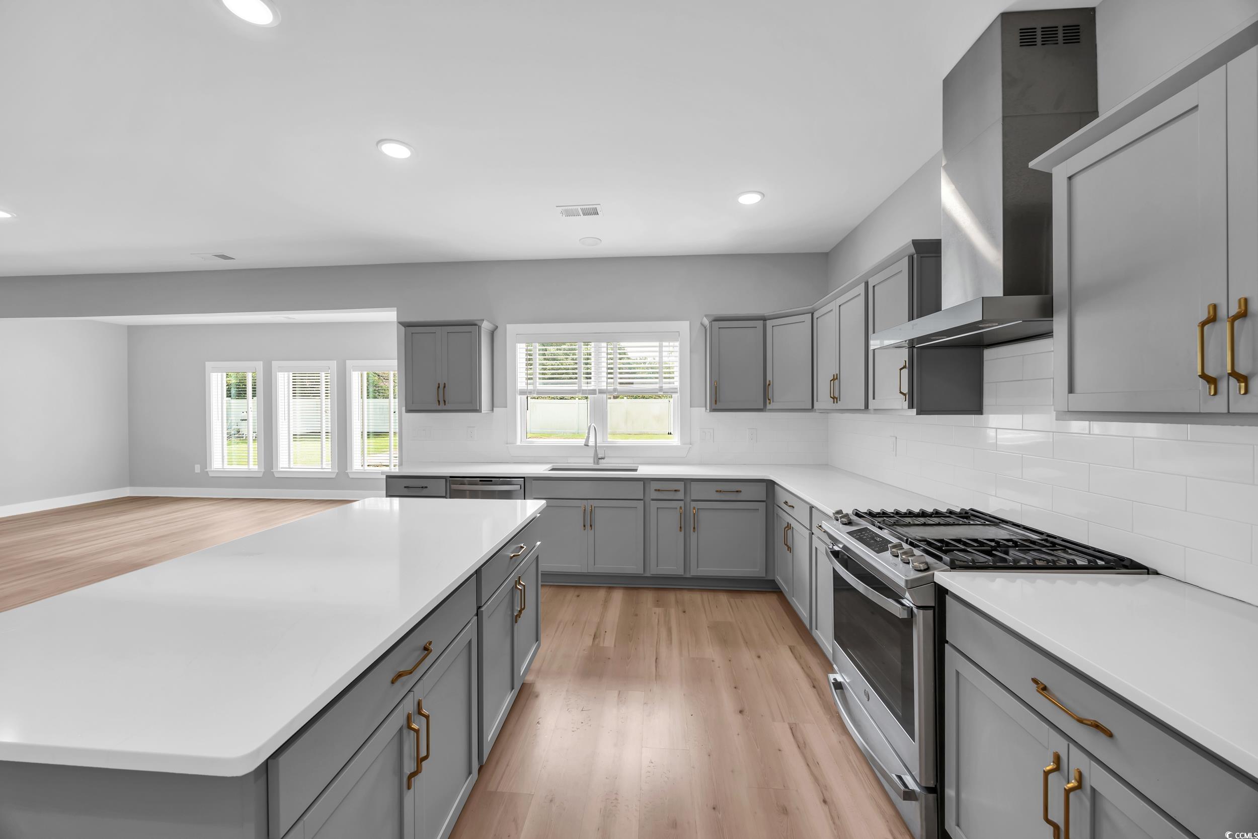 1121 Grimes Street Georgetown, SC 29440 - Photo 11 of 27 Kitchen with gray cabinetry, appliances with stainless steel finishes, wall chimney exhaust hood, and recessed lighting