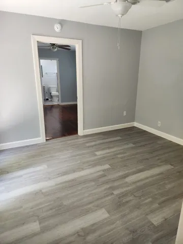 an empty room with wooden floor and mirror
