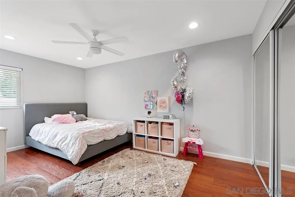 5673 Raintree Way Oceanside, CA 92057 - Photo 16 of 23 a bedroom with a bed chandelier and a window