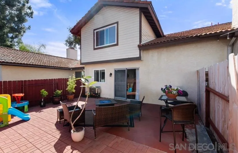 5673 Raintree Way Oceanside, CA 92057 - Photo 20 of 23 a view of a patio with table and chairs potted plants with wooden fence