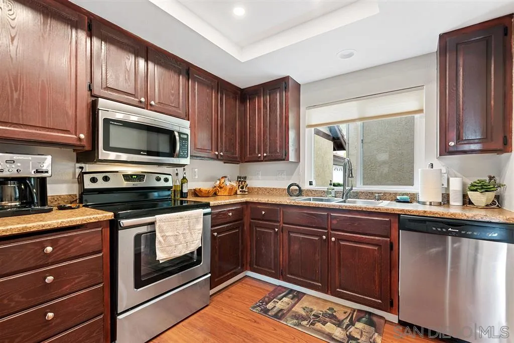 5673 Raintree Way Oceanside, CA 92057 - Photo 6 of 23 a kitchen with stainless steel appliances granite countertop a sink stove and microwave