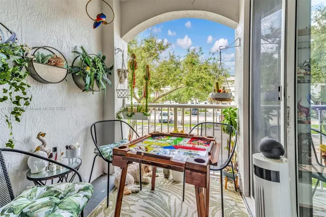 a view of a dining room with furniture a potted plant and a floor to ceiling window