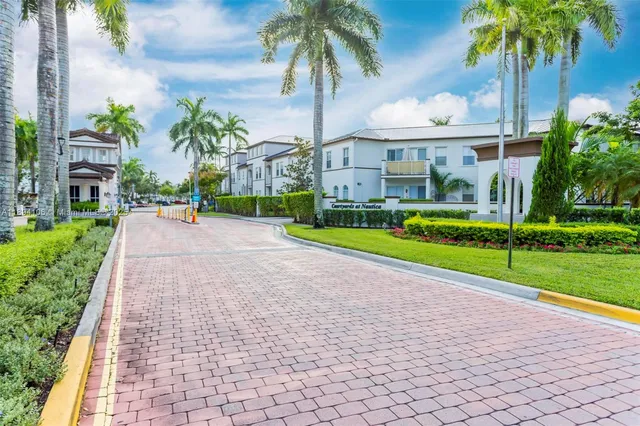 a view of a house with a yard and palm trees