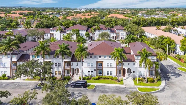 an aerial view of residential houses with outdoor space and ocean view