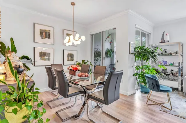 a dining room with furniture potted plants and wooden floor