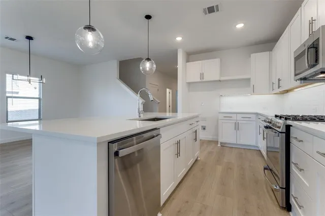 a kitchen with a sink a counter space appliances and a cabinets
