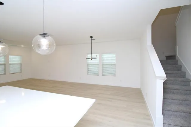 a view of a room with a chandelier fan and windows
