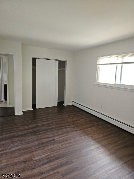 156 Highway 46, Unit 22 Rockaway, NJ 07866 - Photo 7 of 10 an empty room with wooden floor and windows