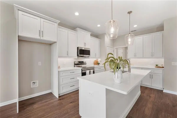 a kitchen with white cabinets and stainless steel appliances