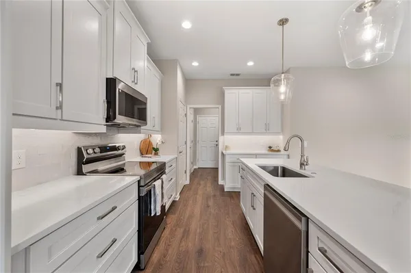 a kitchen with stainless steel appliances a sink stove and wooden cabinets