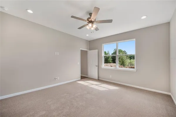 an empty room with a ceiling fan and window