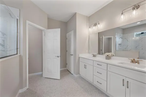a spacious bathroom with double sink and a mirror