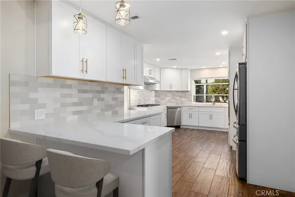 a kitchen with stainless steel appliances white cabinets and a window