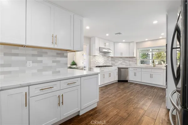 a kitchen with granite countertop white cabinets and white appliances