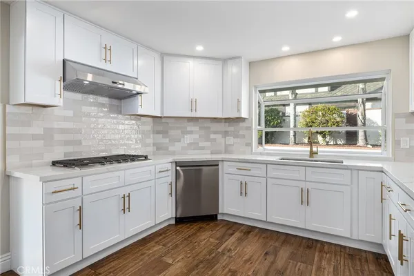 a kitchen with stainless steel appliances kitchen island granite countertop a stove a sink and a refrigerator