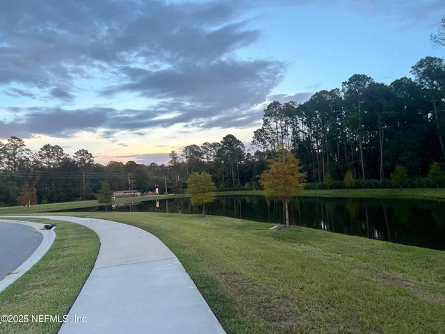 a view of house with backyard and trees