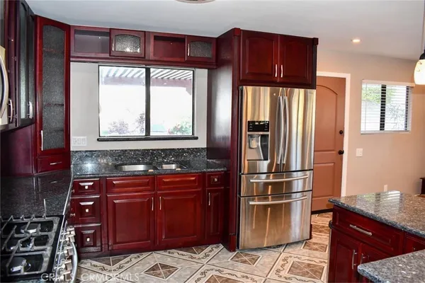 a kitchen with stainless steel appliances granite countertop a refrigerator and a stove top oven