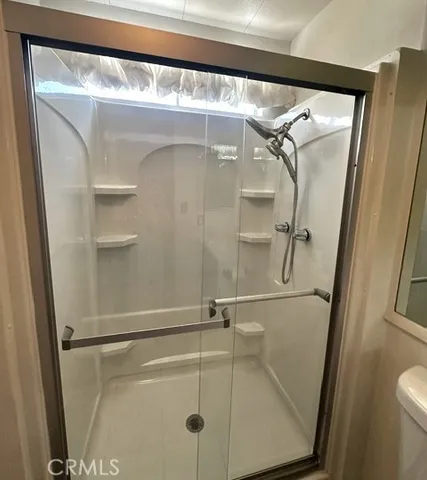 a bathroom with a glass shower door and mirror