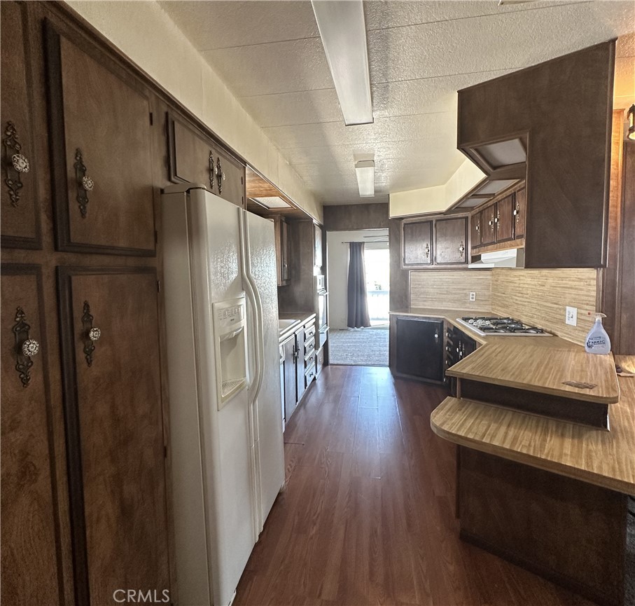 950 California Street, Unit 60 Calimesa, CA 92320 - Photo 9 of 26 a kitchen with stainless steel appliances granite countertop a refrigerator a stove and a wooden floors