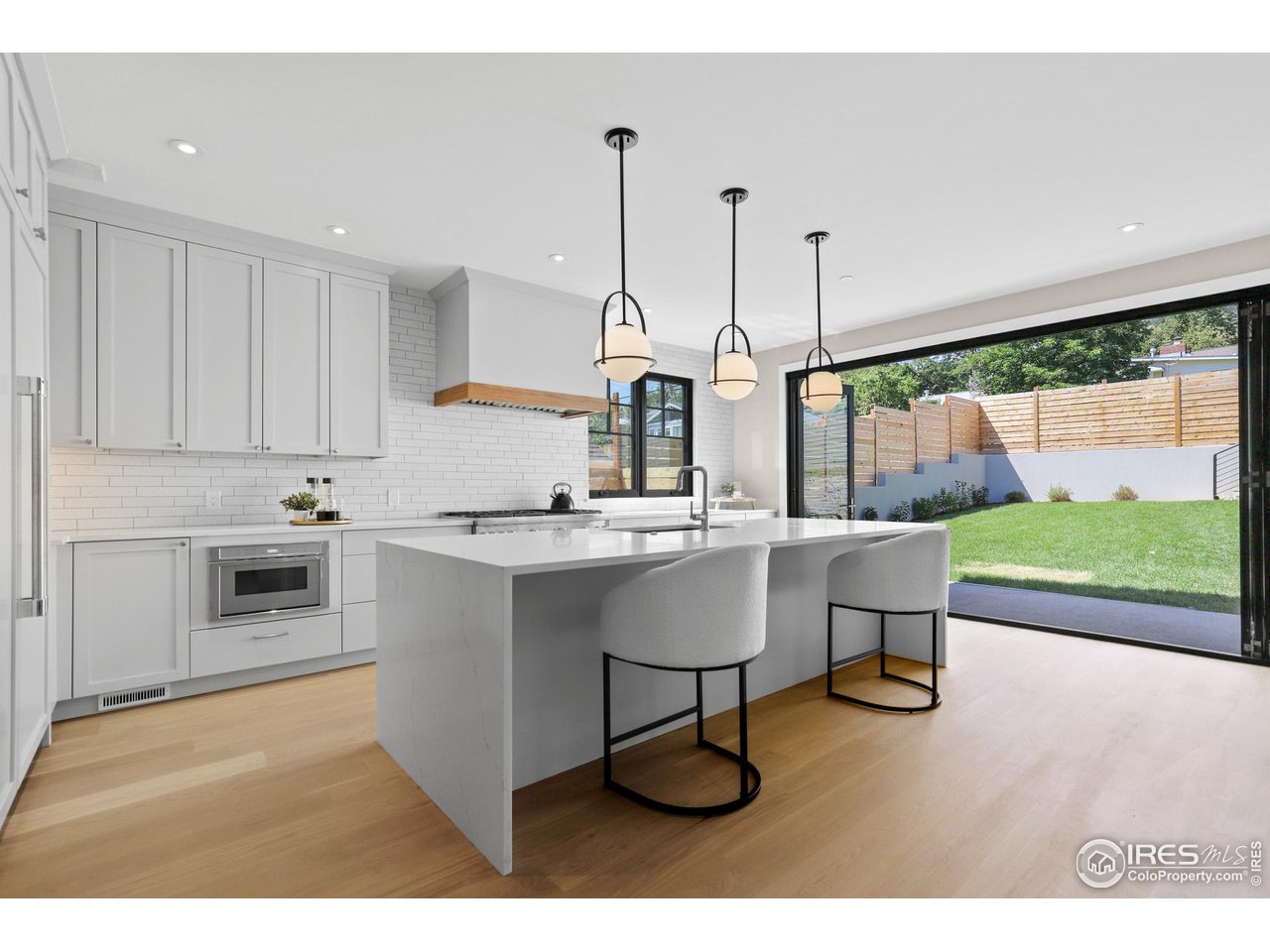 3063 7th Street Boulder, CO 80304 - Photo 4 of 39 a kitchen with stainless steel appliances granite countertop a stove a sink dishwasher and white cabinets with wooden floor