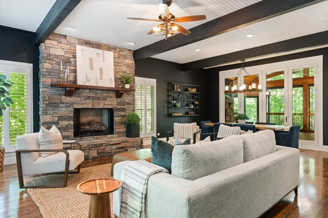 a living room with furniture a fireplace and a large window