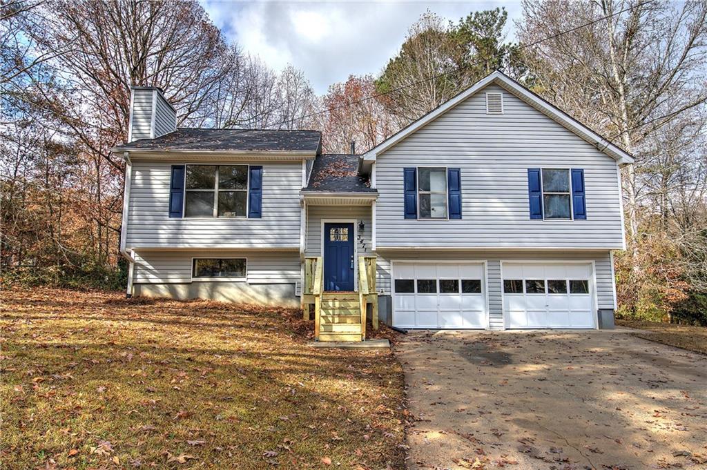 a view of a white house with large windows next to a road