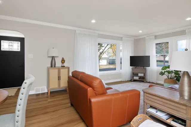 a living room with furniture a flat screen tv and a window