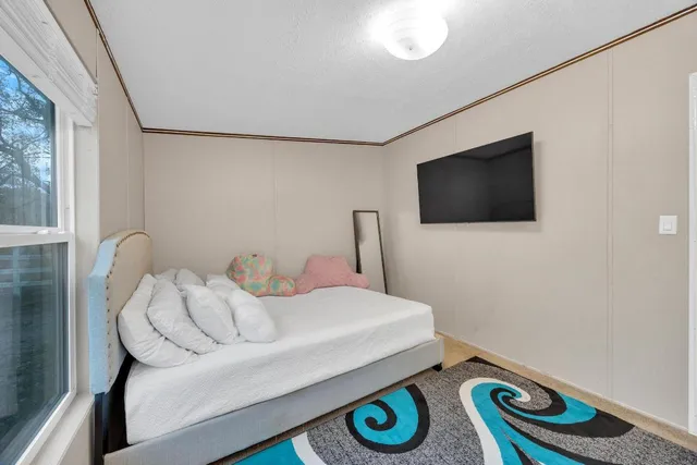 a bedroom with a bed and a flat screen tv