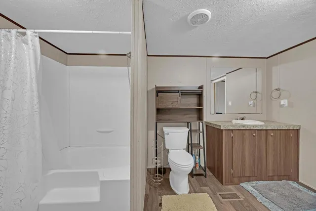a bathroom with a toilet a sink and shower