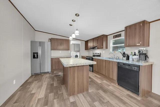 a kitchen with kitchen island a sink stainless steel appliances and cabinets