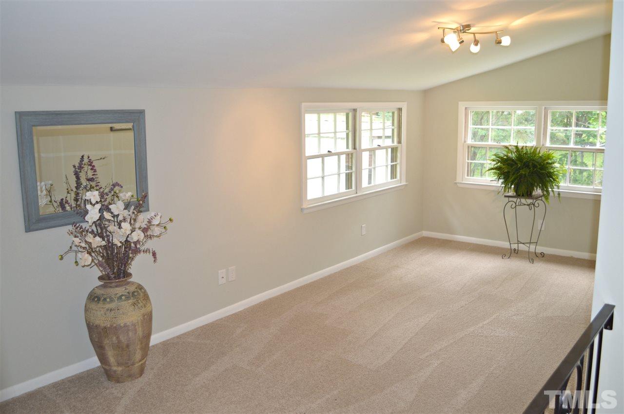 3333 Friar Tuck Road Raleigh, NC 27610 - Photo 12 of 21 an empty room with a chandelier fan and wooden floor