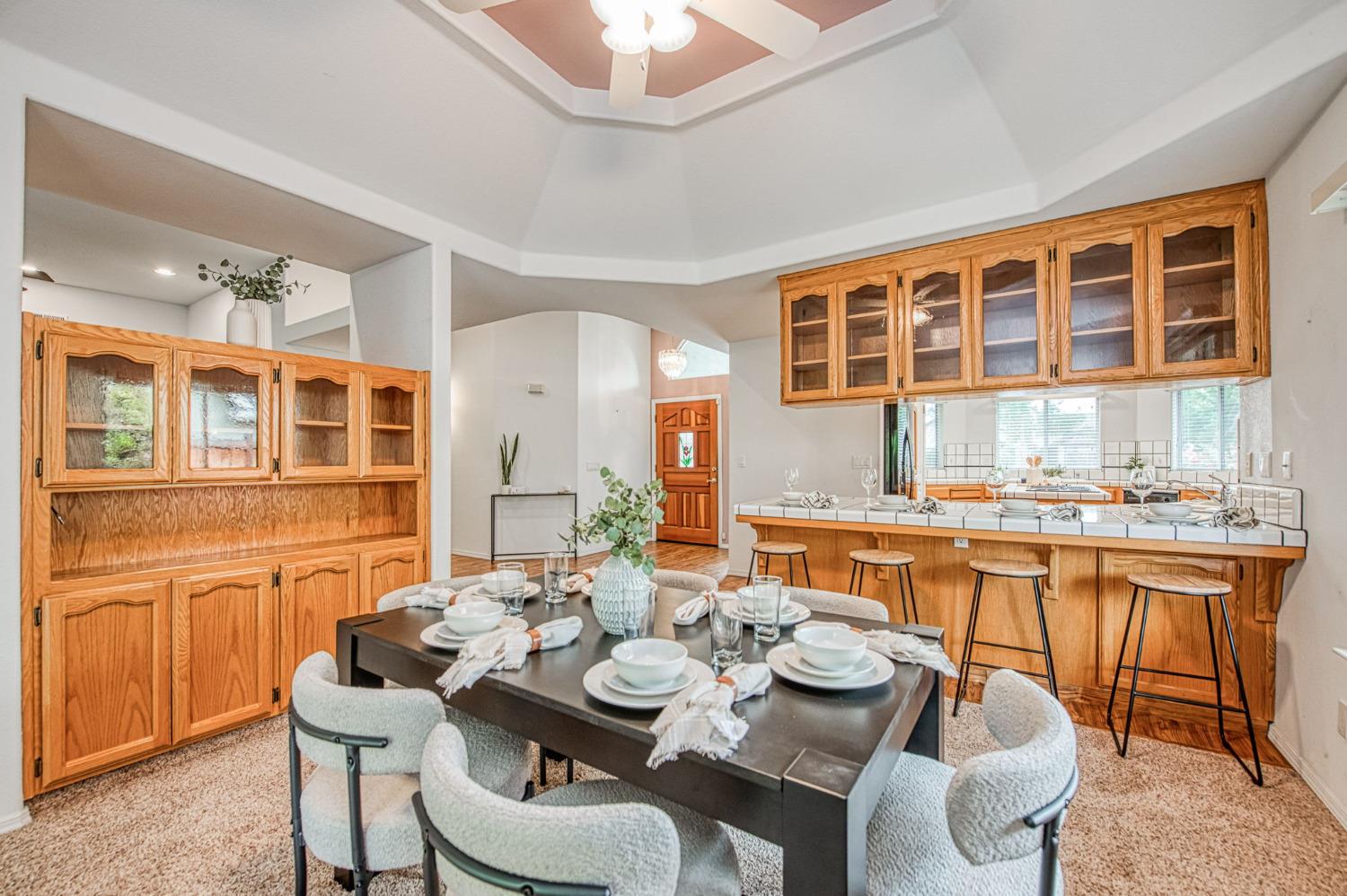 3225 Filbert Avenue Clovis, CA 93611 - Photo 11 of 36 a dining room with furniture a kitchen and chandelier